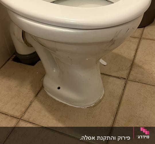 אסלה לבנה עם כתמים על הרצפה